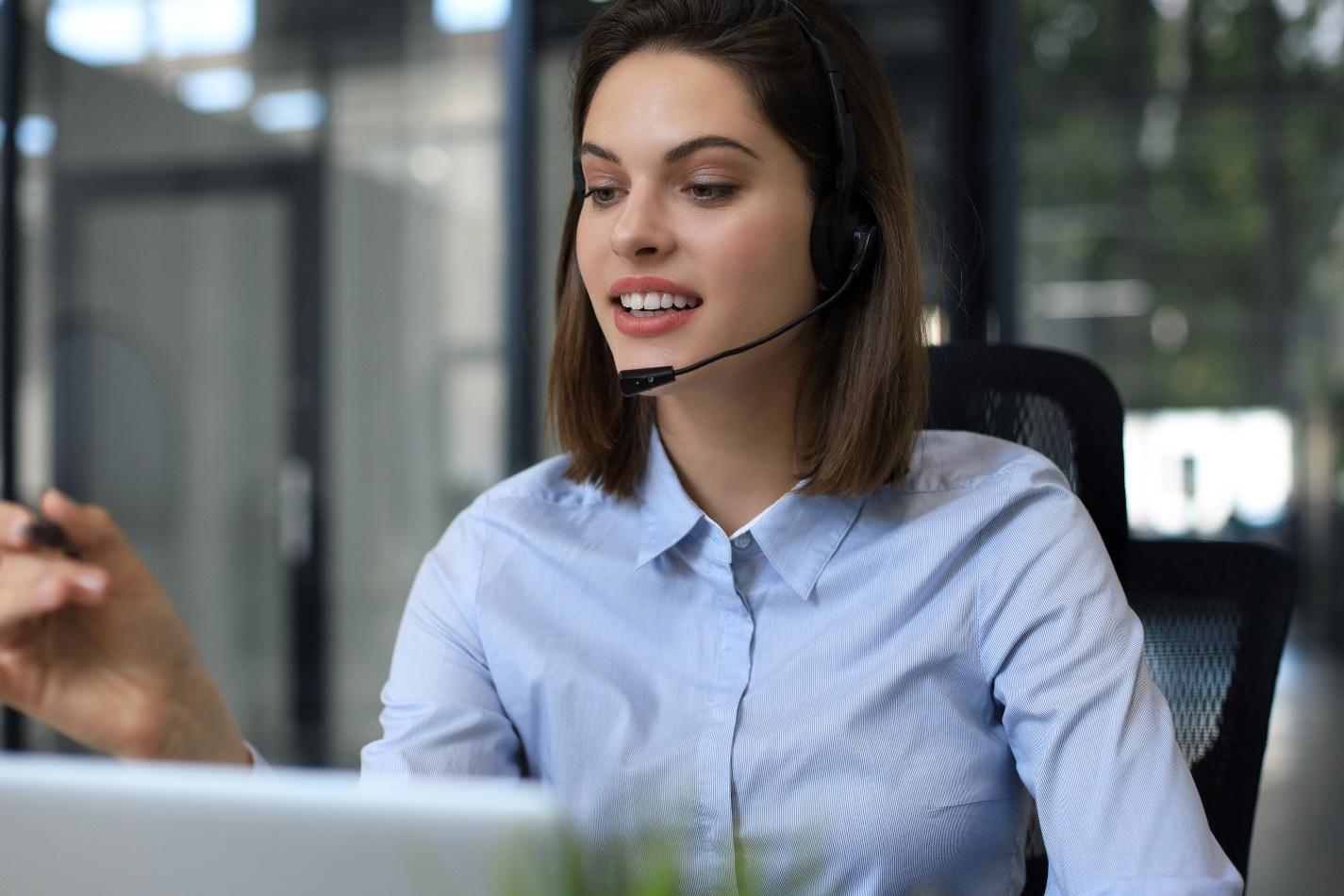 An IT help desk worker with a headset helping a client.